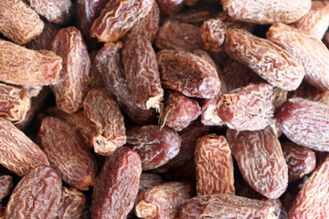 Dried dates close up showing dense pile with wrinkled skins and natural colors