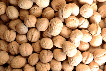 Whole walnuts close up showing tightly packed pile with natural shells and textures