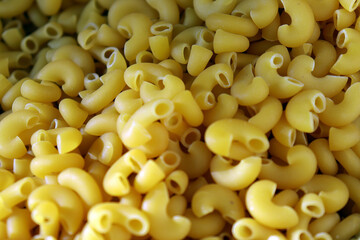 Elbow macaroni pasta uncooked golden yellow pasta background