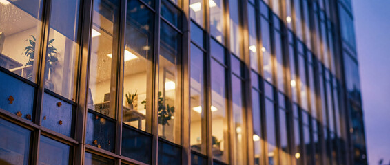 Close-up of a modern high-rise office plaza exterior with illuminated windows.