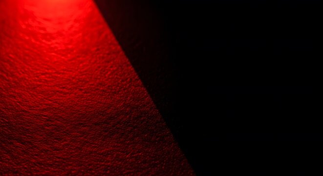 Dramatic red light beam shining on a dark surface creating a spotlight effect