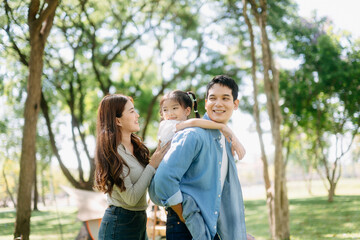 Happy parents and daughter Bakery and Bread Fruit enjoy  in a sunny garden. A joyful summer picnic full of love, food for family, outdoor