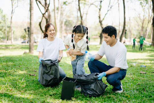 Asian parents and child collect trash in the forest, promoting recycling, unity, and ecology. A heartwarming scene of love, care, teamwork - Powered by Adobe