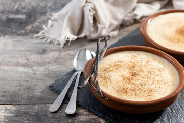 Creamy homemade Spanish custard served in a bowl on wooden table. Copy space