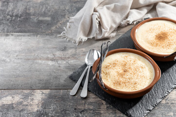 Creamy homemade Spanish custard served in a bowl on wooden table. Copy space