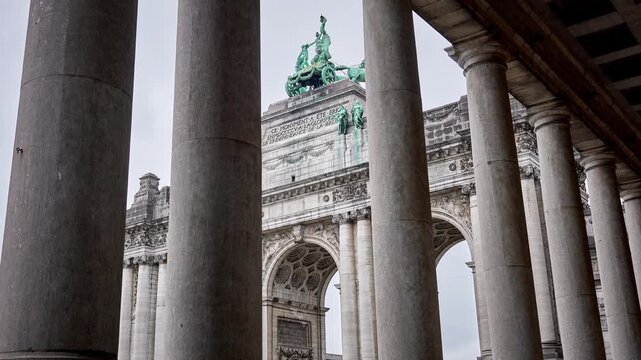 Triumphal Cinquantenaire Arch in Brussels, Belgium seen through army museum colonnade columns