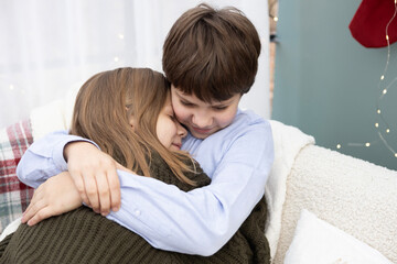 Siblings sharing a warm embrace on a cozy winter day in a beautifully decorated living room