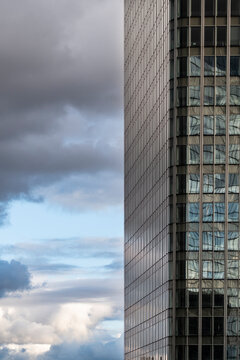 Architecture and skyline in an urban scene where building facade and glass reflection define the modern city below a dramatic sky with ample copy space for branding