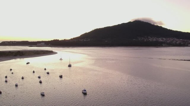 soft sunrise light over calm waters and anchored boats near monte santa tecla
