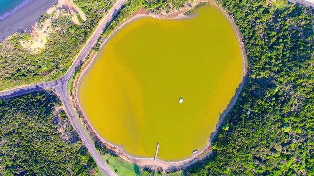 Top-down drone shot of the yellowish Siloam Lake in Beachport, South Australia. Overhead view capturing its unique warm tones, shoreline textures. Ideal for travel and nature footage.