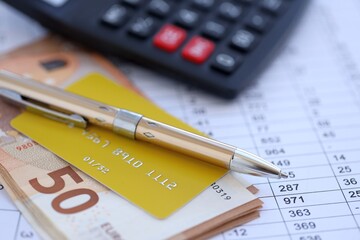 Credit card and pen with euro currency money bills banknotes on calculations document background. Business, financial operations and accounting in European Union