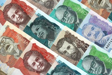Colombian pesos money bills banknotes lies in big pile on table close up. Concept of finances and...
