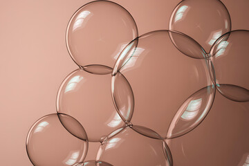 Transparent soap bubbles floating and overlapping against a soft peachcolored background, creating a delicate and ethereal abstract pattern