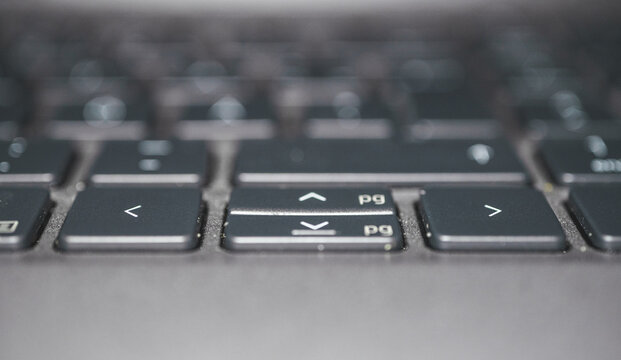 Close up macro photograph of computer keyboard arrow keys in soft light.