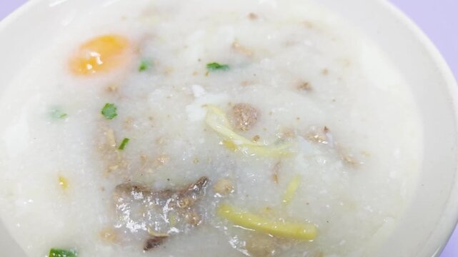 Rice porridge or congee with pork egg sliced ginger and vegetable. Delicious breakfast.