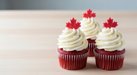 Red velvet cupcakes with cream frosting and maple leaf decoration for Canada Day  