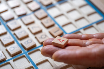 closeup hands carefully placing number into Sudoku puzzle, senior man focused on solving puzzle on wooden board, Brain exercise, cognitive health, and mental agility in mature age, brain health