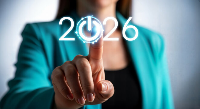 Hand pressing a glowing 2026 power button, representing the start of a new year and future goals