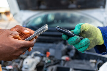 Mobile money, African mechanic receiving payment from customer after car repair