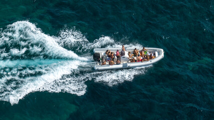 Aerial view of people on vacation on a dinghy sailing the blue sea. Holiday boat concept. © Stefano Tammaro