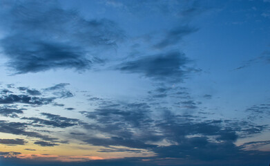 Brilliant sky glowing with colorful sunset shades across late afternoon clouds