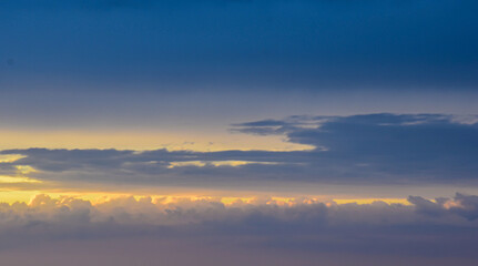 Majestic sunset sky radiating magical colors across softly illuminated clouds