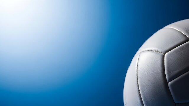 Close up of a volleyball on a blue background with bright light