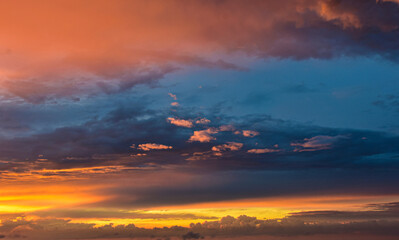 Radiant evening sky illuminated by warm sunset glow through drifting clouds