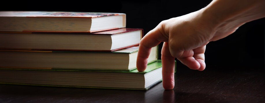 Hand walking on a ladder made of books