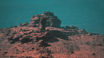 Beneath a hazy sky, a stunning rock formation stands proud amidst the rugged desert terrain. Dusty earth tones reflect the timeless beauty of this remote location, inviting exploration.