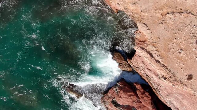 Skaliste wybrzeże fale czerwone skały