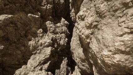 Sunlight streams down into a narrow canyon, illuminating rough stone walls and shadows. The rugged terrain invites exploration and adventure among the natural formations.