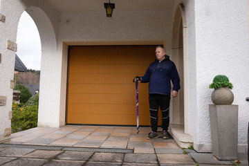 older man goes for a walk with  hiking poles