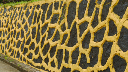 Abstract Textured Wall with Yellow Pattern on Dark Stone Surface