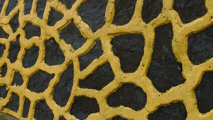 Abstract Textured Wall with Yellow Pattern on Dark Stone Surface