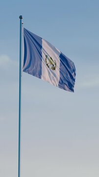 Guatemala, Guatemala City: Cinematic Vertical Waving National Flag Against Blue Sky