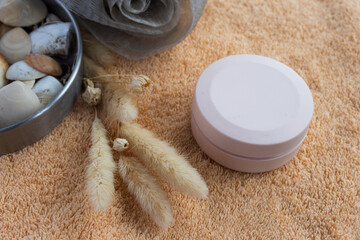 Spa products with natural decorative elements, and an orange towel creating a calming atmosphere for personal beauty routines