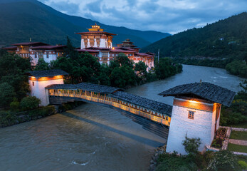 Aerial view of the majestic Punakha Dzong, a fortress of white walls and golden roofs, mirrored in the flowing river, Punakha, Punakha, Bhutan.