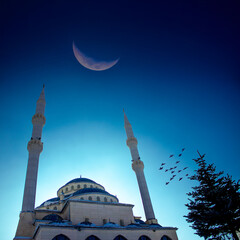 Ramadan or Islamic background photo: Al-Kazan Mosque under crescent moon.