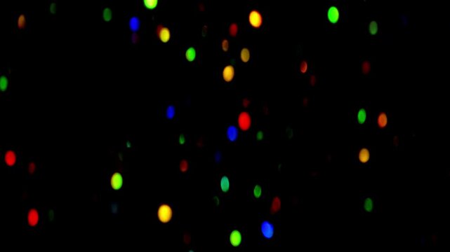 Fast-Flashing Multicolored Confetti Bokeh. Rapid flickering of vibrant colorful light spots resembling dancing confetti against deep black background in energetic motion.  