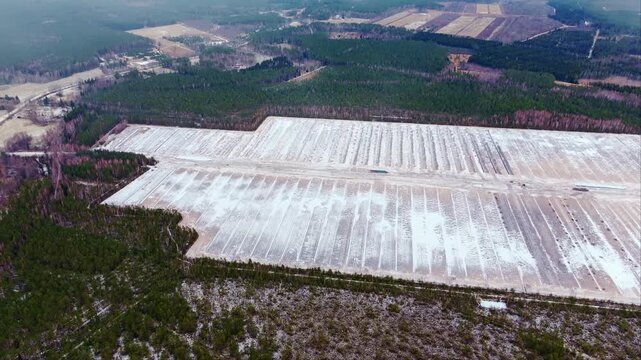 Snow gently falls on structured peat extraction fields in Latvia&rsquo;s Cenu wetland
