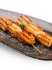 Grilled salmon skewers served on a black plate for a delicious meal