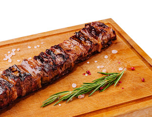 Grilled steak on wooden cutting board garnished with herbs