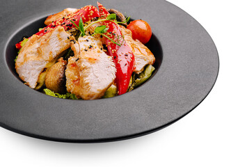 Delicious grilled chicken served with fresh vegetables on a black plate