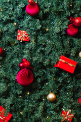 Top-down view of a Christmas tree decorated with red gifts and golden ornaments