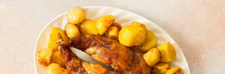 A beautifully presented dish features a whole baked rabbit surrounded by tender, golden-roasted potatoes. This comforting meal is perfect for family gatherings or special occasions, banner