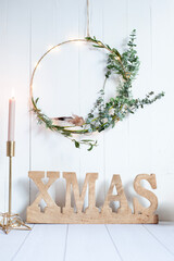 Golden "XMAS" Letters with Dried Flower Wreath and Candle on White Background