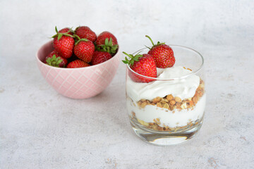 Yogurt Parfait with Granola in a Glass decorated with fresh stawberry
