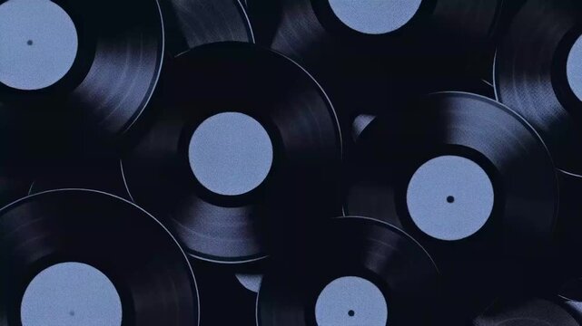 A collection of black vinyl records stacked together, showcasing their shiny surfaces and circular holes.