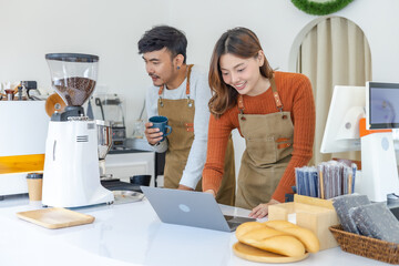 Happy couple entrepreneur reviewing sales report on laptop in small business cafe, joyful baristas celebrating turnover growth, representing success, digital management technology, startup confidence